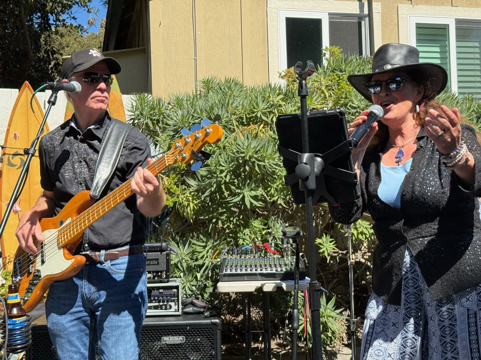 Chris Daniel playing bass alongside Kate Daniel singing on stage